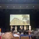 A group of people stand on a stage during a presentation.