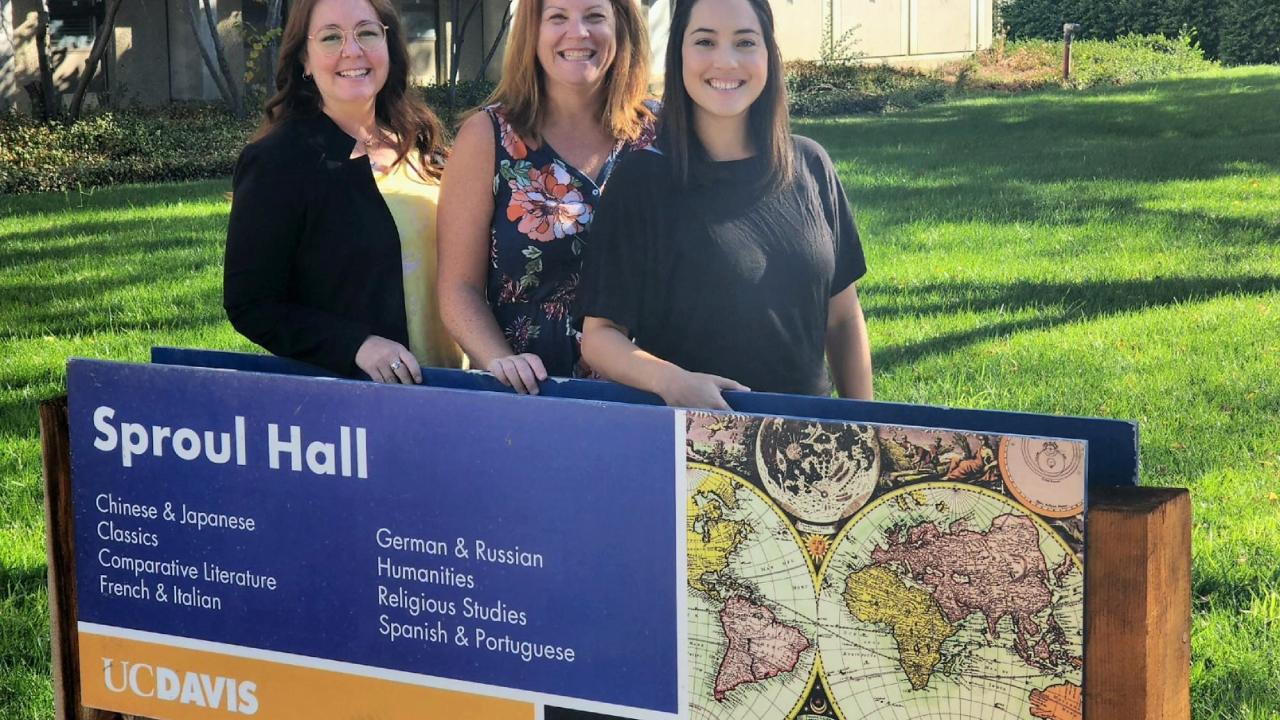 Your advising team standing behind a sign for sproul hall