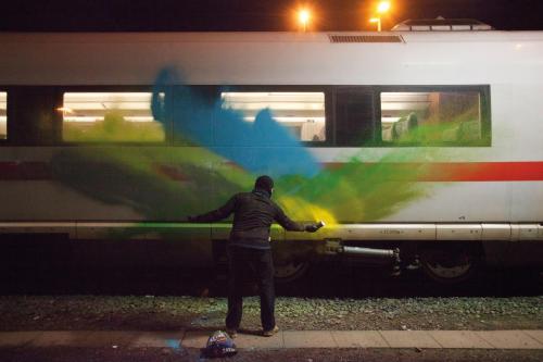 A photo of a figure splashing main on a modern train car.