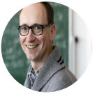 A headshot of a man wearing glasses